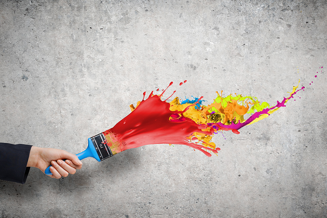Hand mit Pinsel und Farbe an der Wand